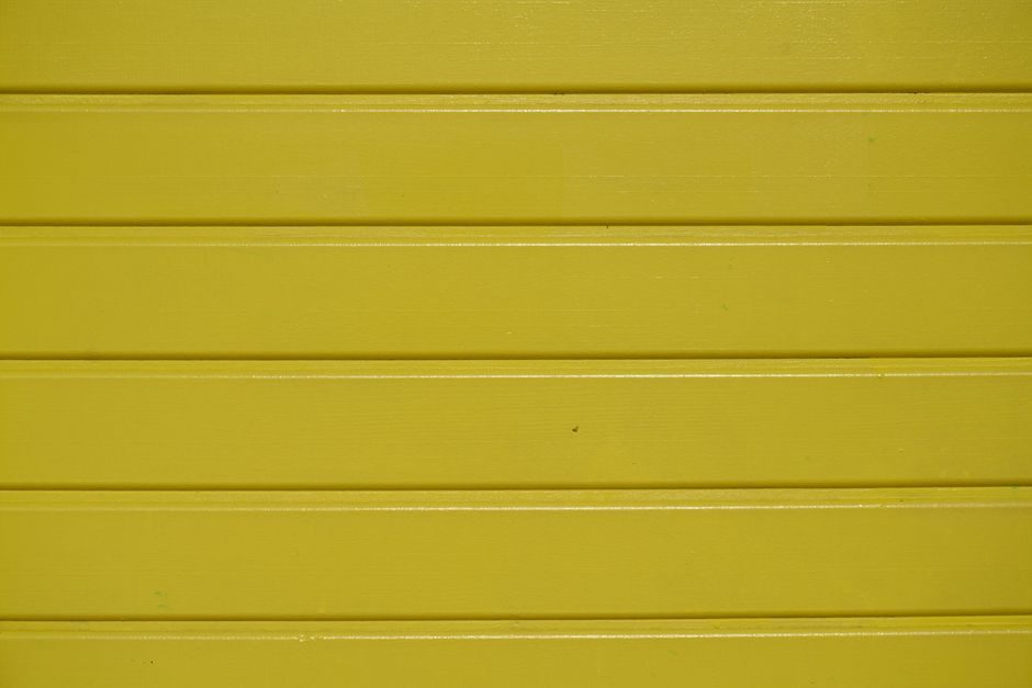 苍黄 — Close-up of a vibrant yellow wooden wall with textured planks.