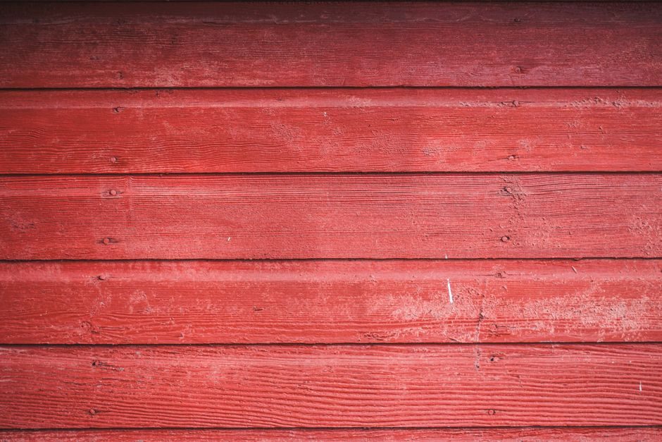 唇脂 — Detailed view of rustic red wooden siding showcasing rich texture and natural grain.
