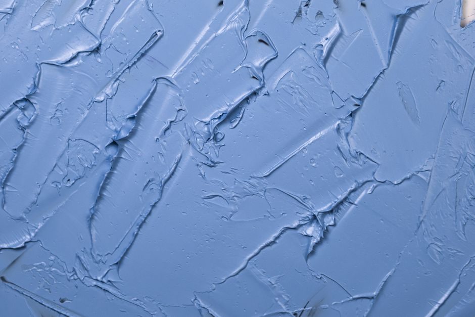 监德 — Textured blue paint background showcasing abstract patterns and artistic expression.