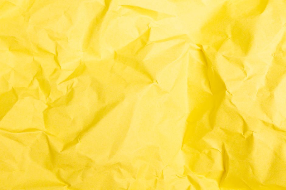 女贞黄 — A detailed close-up of crumpled yellow paper, showcasing its textured surface and vibrant color.