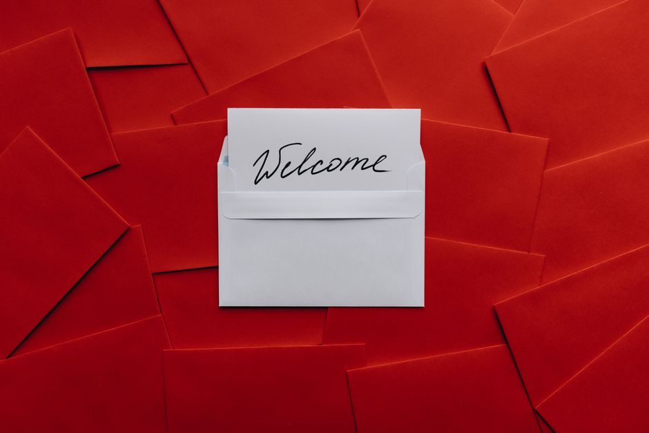 朱樱 — A white card with 'Welcome' text in an envelope against a red envelope background.